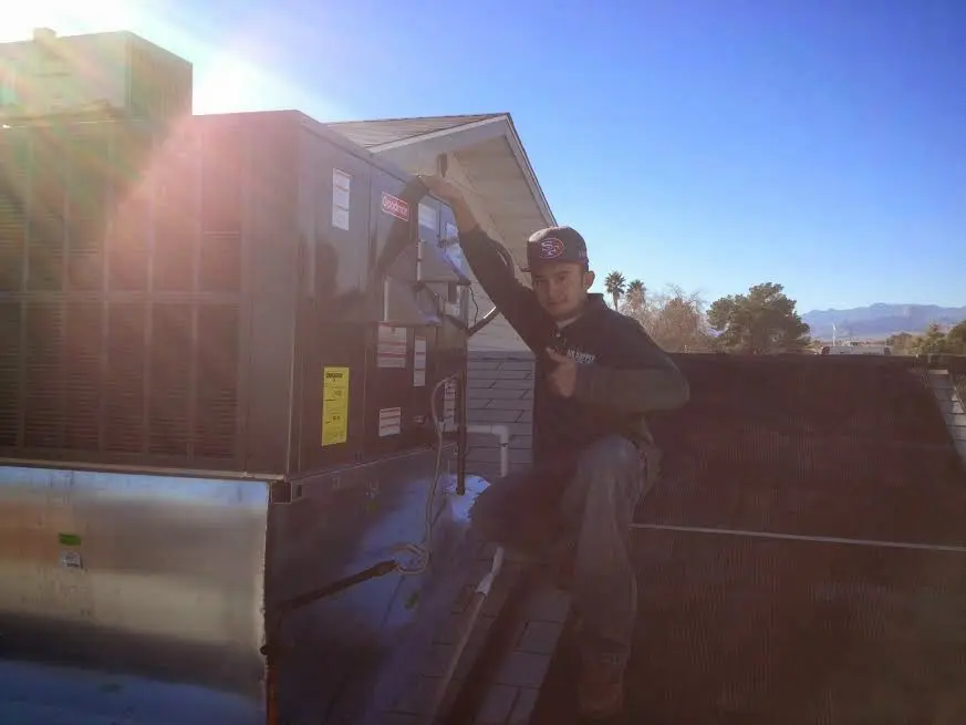 HVAC technician performing Heat Pump Repair on a rooftop unit in Dranesville